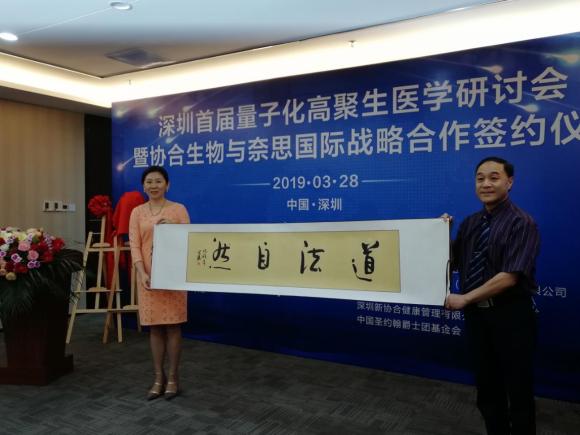 陈艳总裁代表hjc黄金城生物把世界朋友节创始人张井涛会长创作的《道法自然》书法作品赠予田志强院长